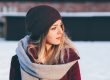 A woman in a winter hat and scarf, looking cozy and warm.