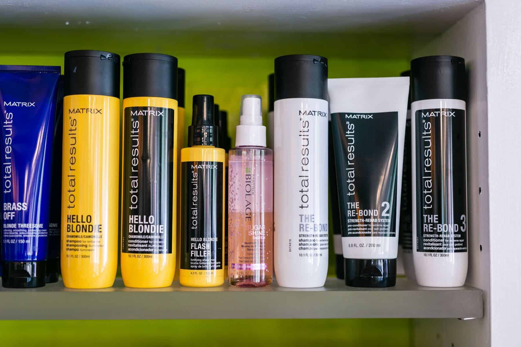 A shelf displaying a variety of hair products, including shampoos, conditioners, styling gels, and hair sprays.