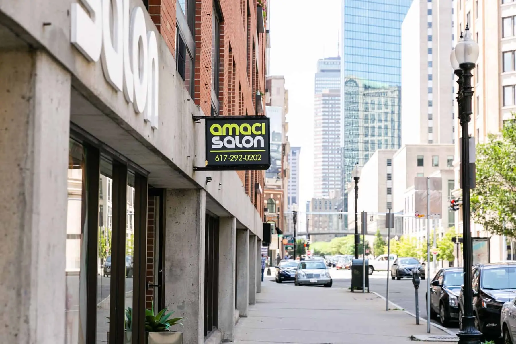 Outside view of Amaci Salon with phone number in a sign board. Located in 230 Stuart Street South Cove Plaza, Boston