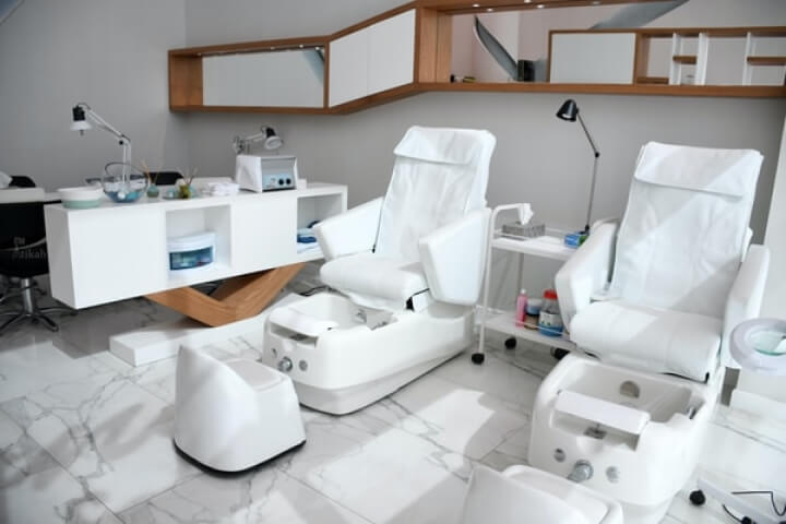 A salon with white chairs and a sink - a modern and stylish space for hair and beauty treatments.