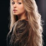 A stunning young woman with blonde balayage rubio flowing hair, radiating beauty and grace.